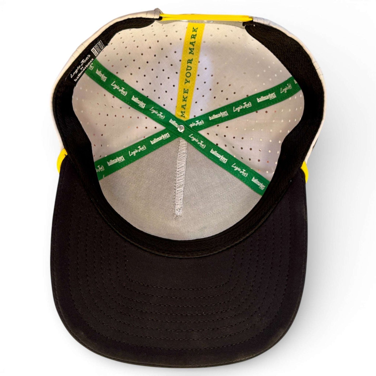 Logie Joe's Golf banana hammock snapback hat with built-in magnetic ball marker holder, adjustable fit, and included marker.