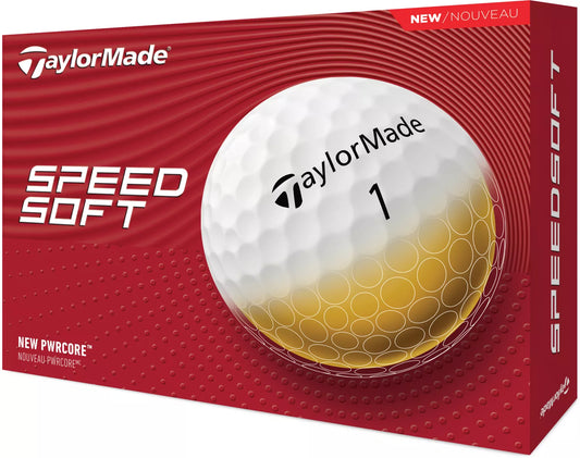 TaylorMade SpeedSoft golf balls in white with red and blue branding, shown on a golf course green.